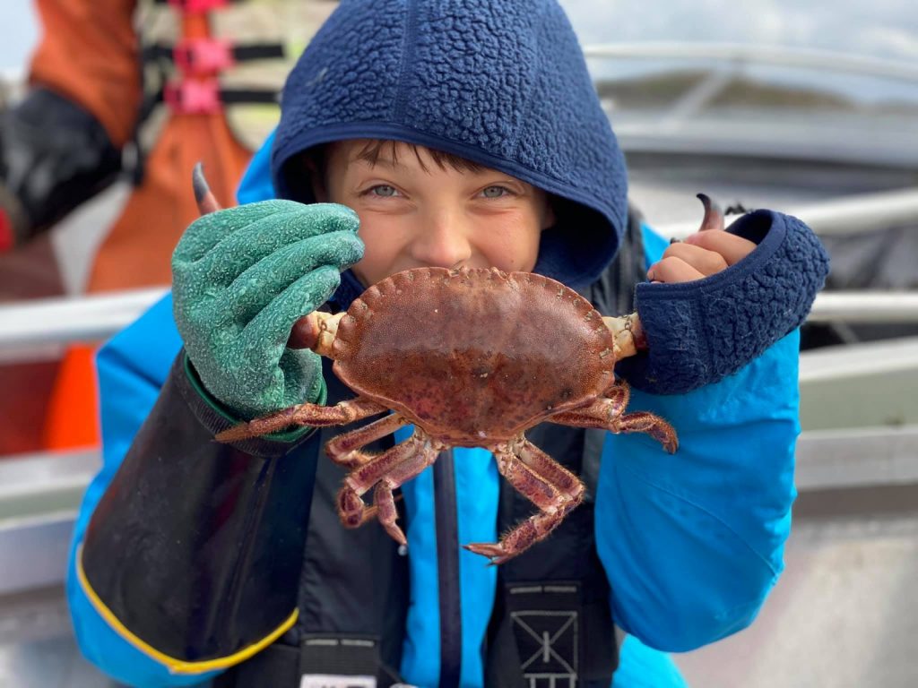 Barn henter opp krabber fra skjærgården utenfor Bogøya i Øyrekka