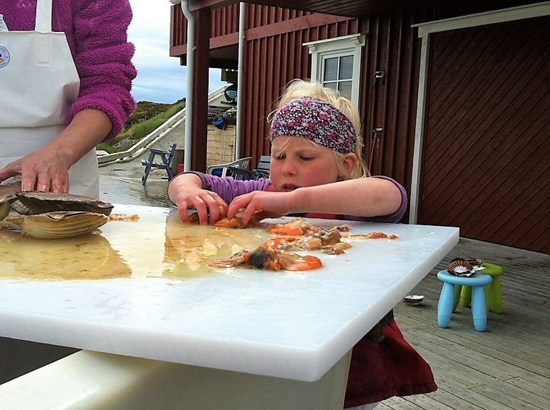 Barn elsker å feriere i Øyrekka - her et barn som ordner opp kamskjell